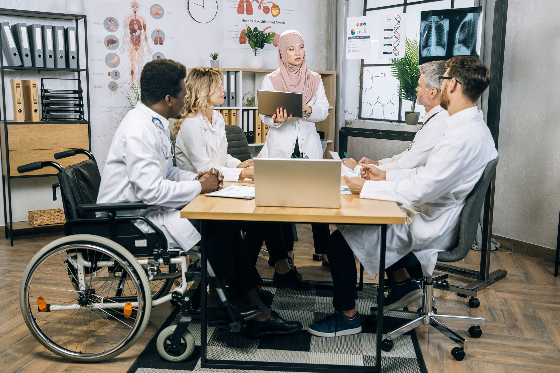 Doctor in hijab having conference with diverse colleagues